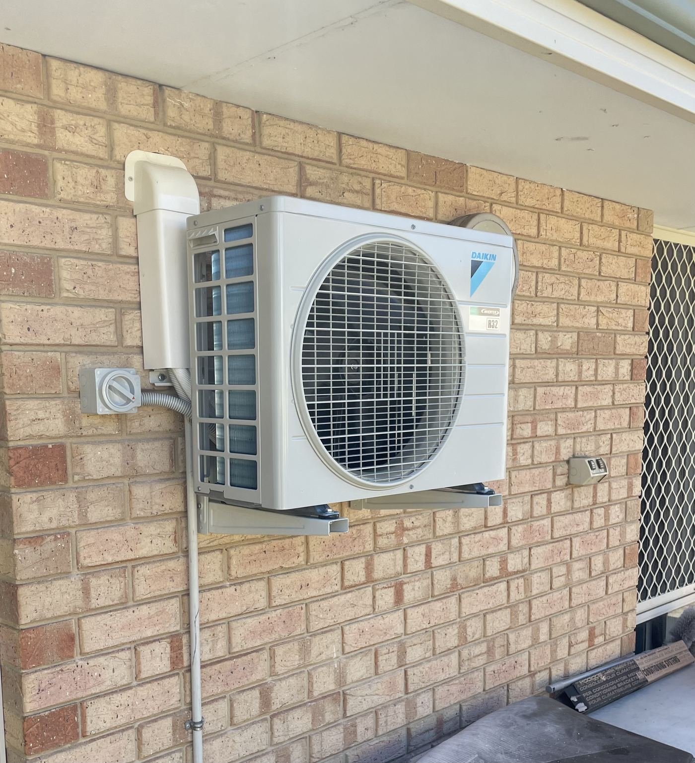 Daikin inverter outdoor unit installed on brick wall