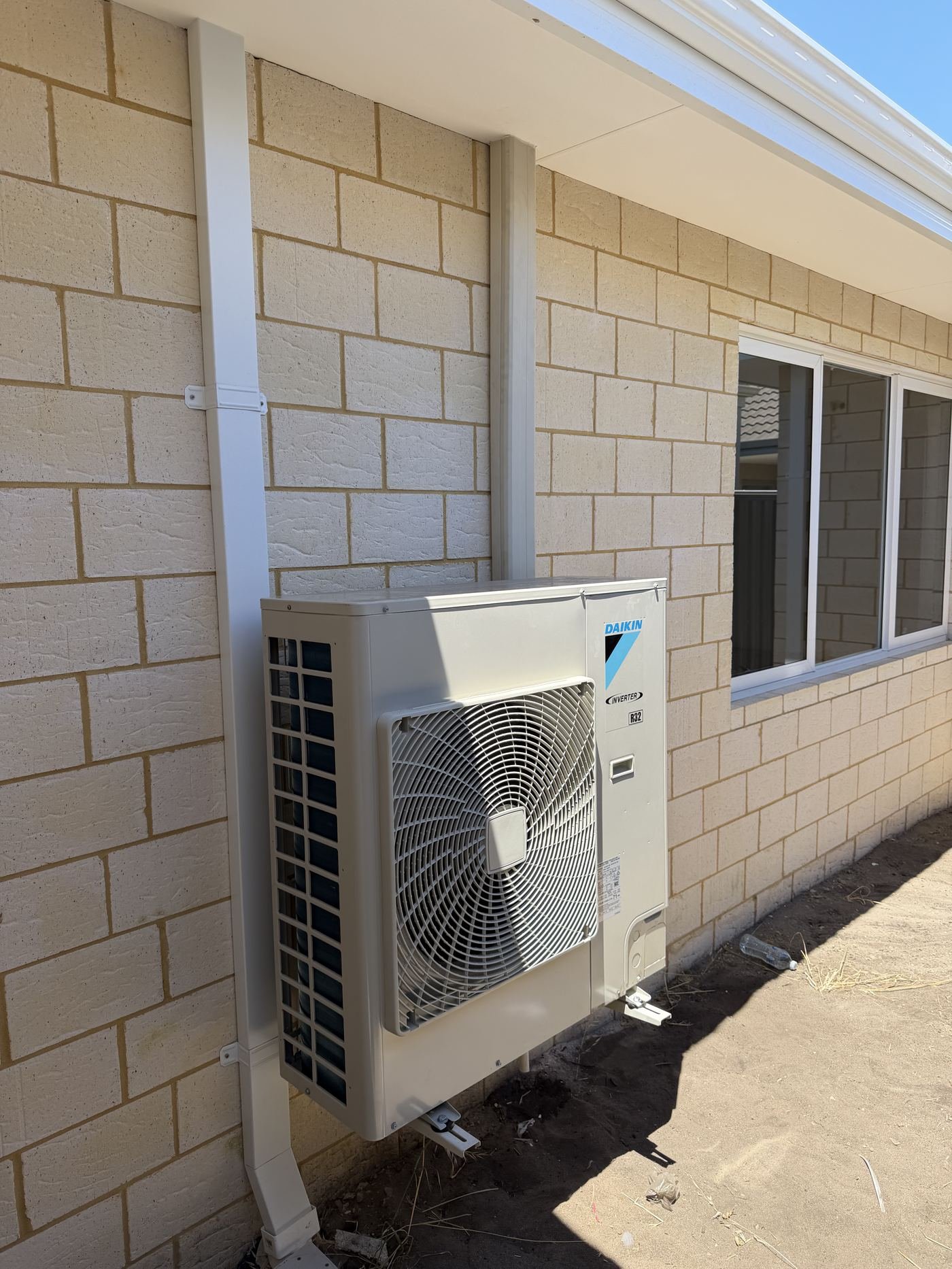 Daikin inverter outdoor unit installed on brick wall