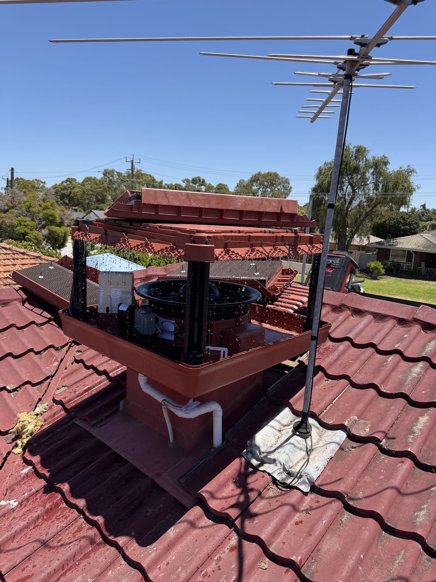 Evaporative cooling unit serviced, close-up on tiled roof